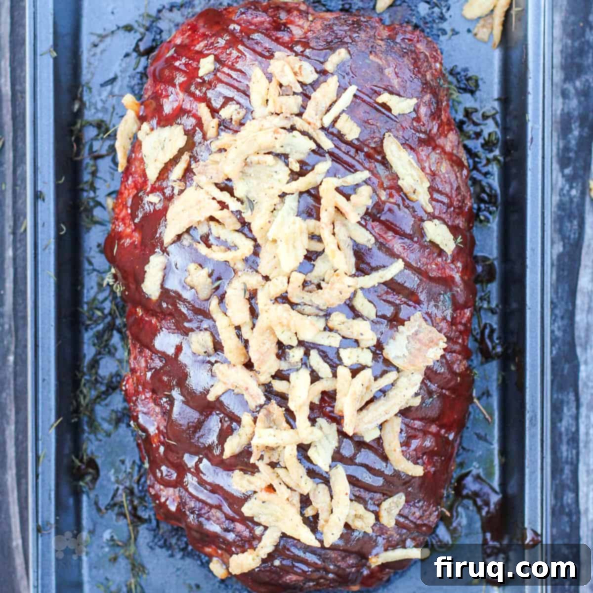Signature Smoked Meatloaf 7 Top-down view of the prepared smoked meatloaf with barbecue sauce and crispy onions, perfectly sliced and ready to serve.