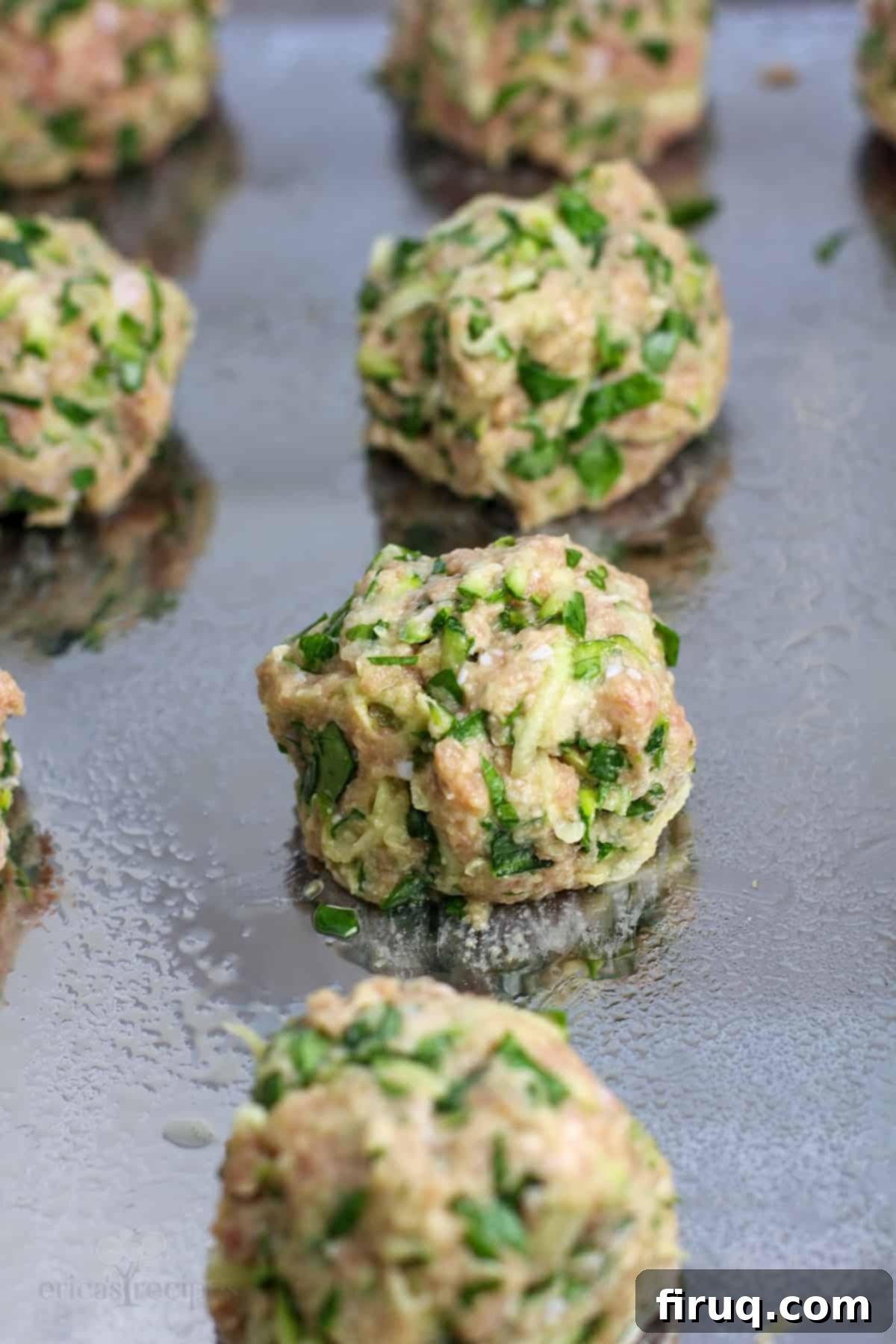 Wholesome Turkey Zucchini Meatballs 4 uncooked meatball on metal bake sheet
