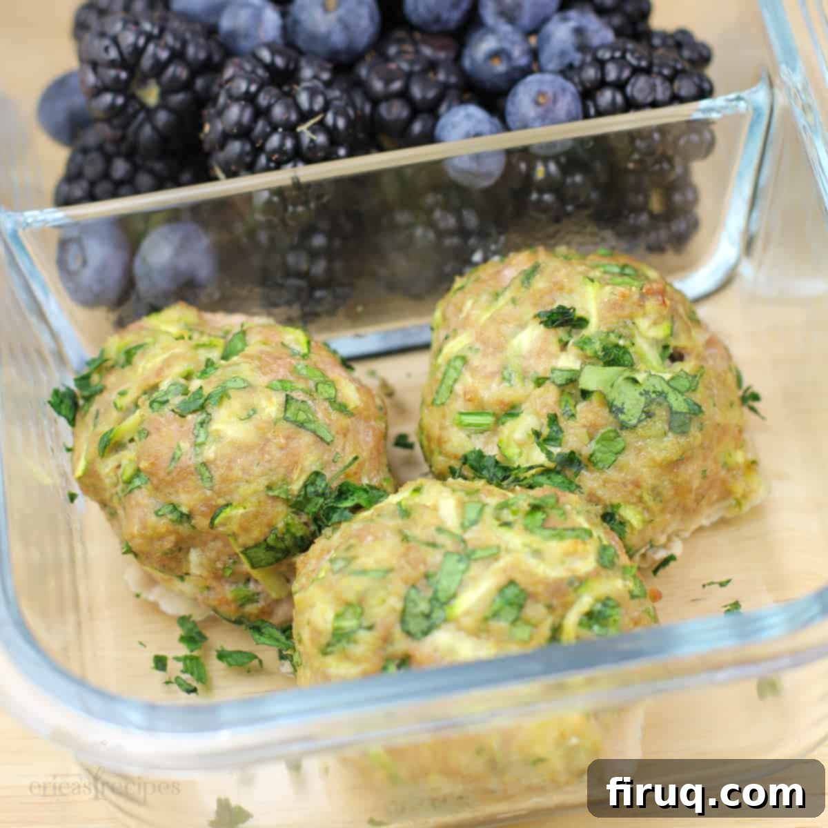 Wholesome Turkey Zucchini Meatballs 9 glass container with 3 cooked meatballs in 1 compartment, blackberries in the other compartment