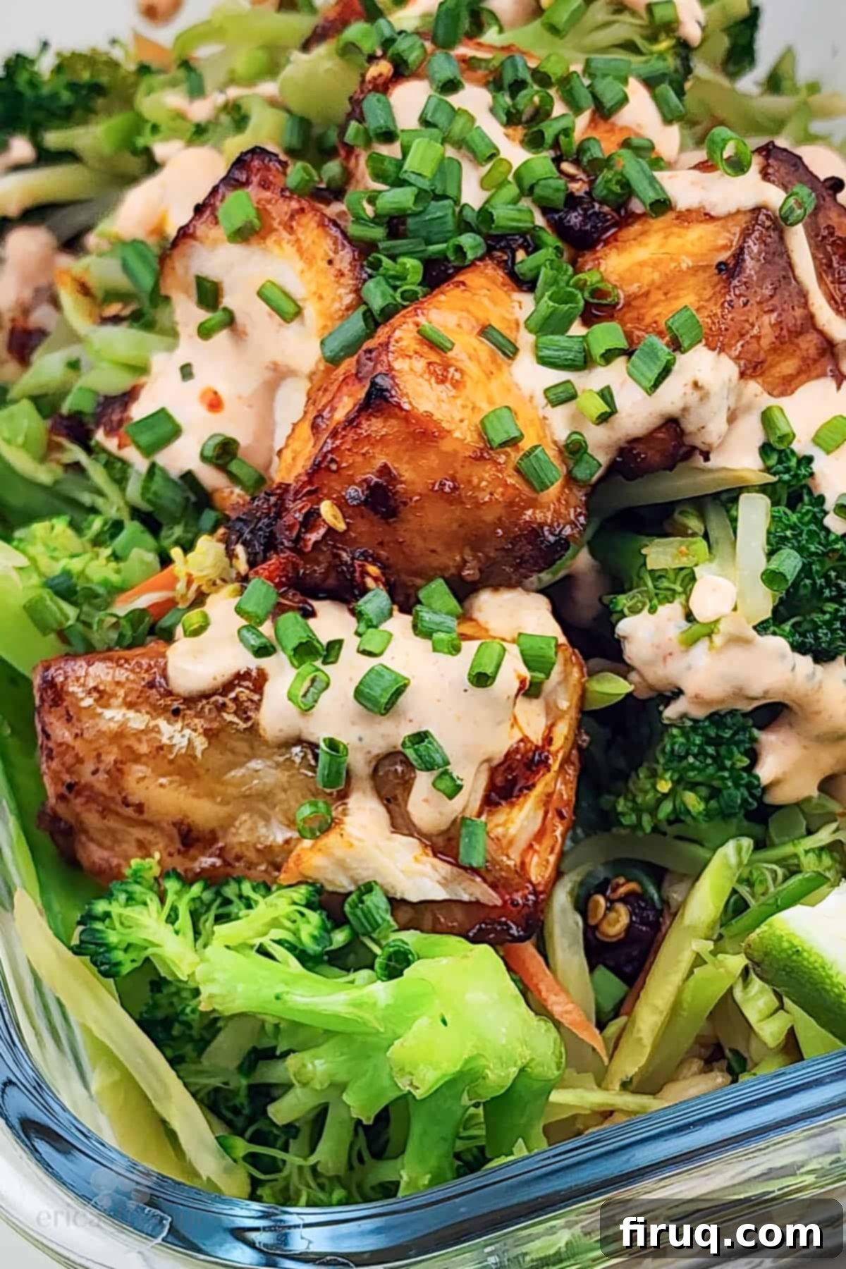 Easy Firecracker Salmon Meal Prep Bowls 2 Prepared firecracker salmon and teriyaki vegetables with brown rice in a meal prep container, ready to eat.