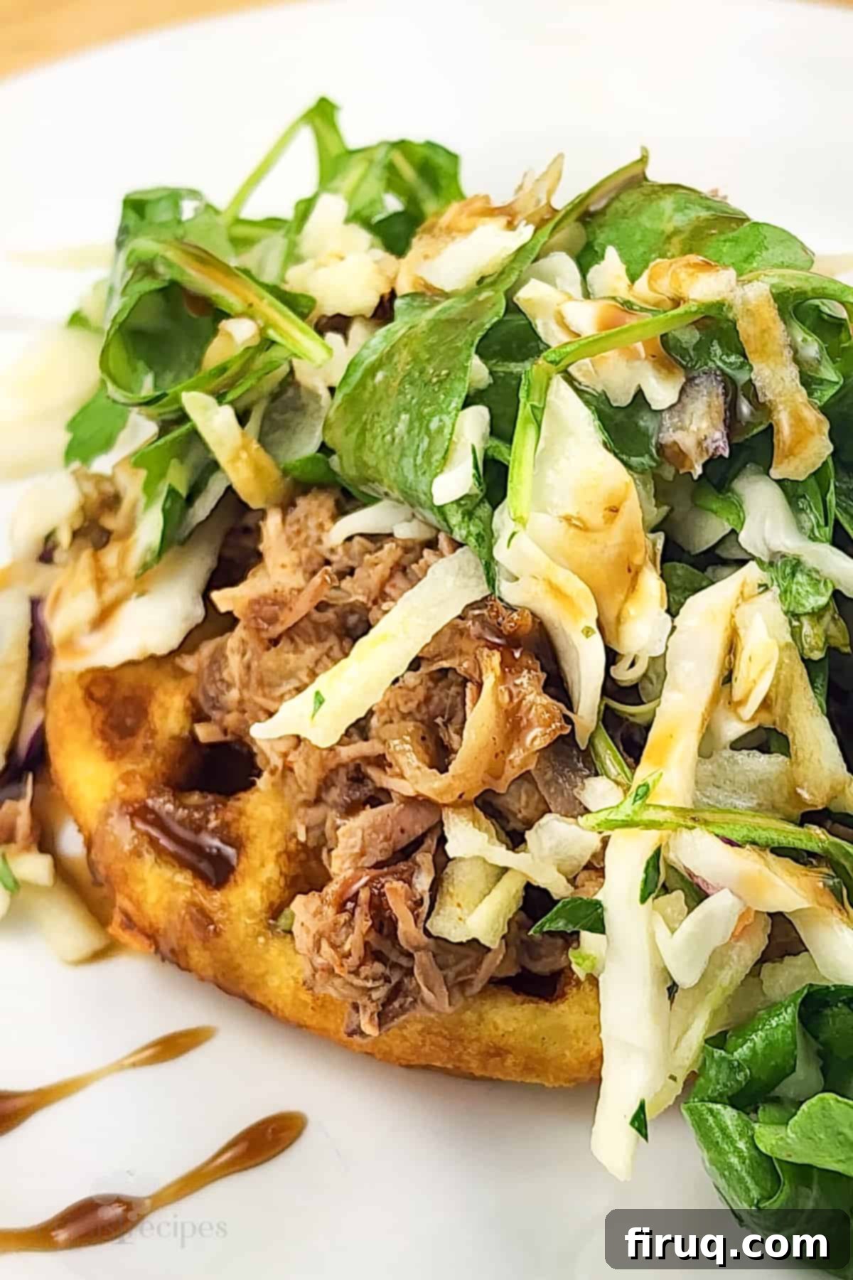 Whiskey-Glazed Pulled Pork on Golden Waffles 3 close-up of prepared pork and waffles recipe on white plate, showing the crispy waffle texture and tender pork