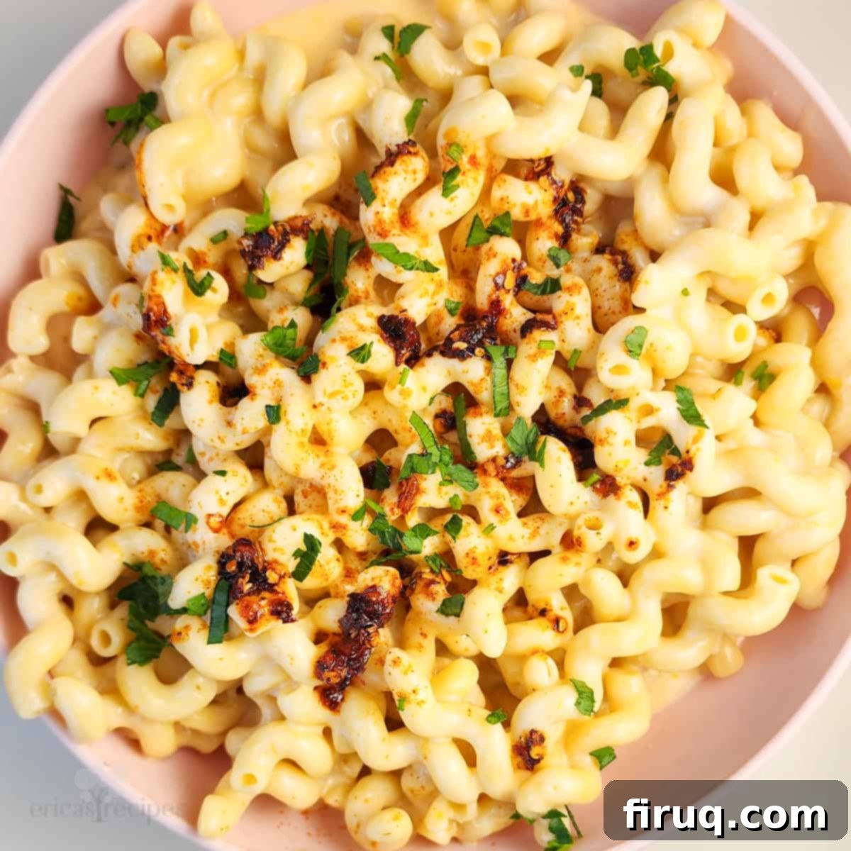 Cottage Comfort Mac 6 A small, round pink bowl filled with the inviting creamy texture of cottage cheese mac and cheese, positioned on a clean white background.