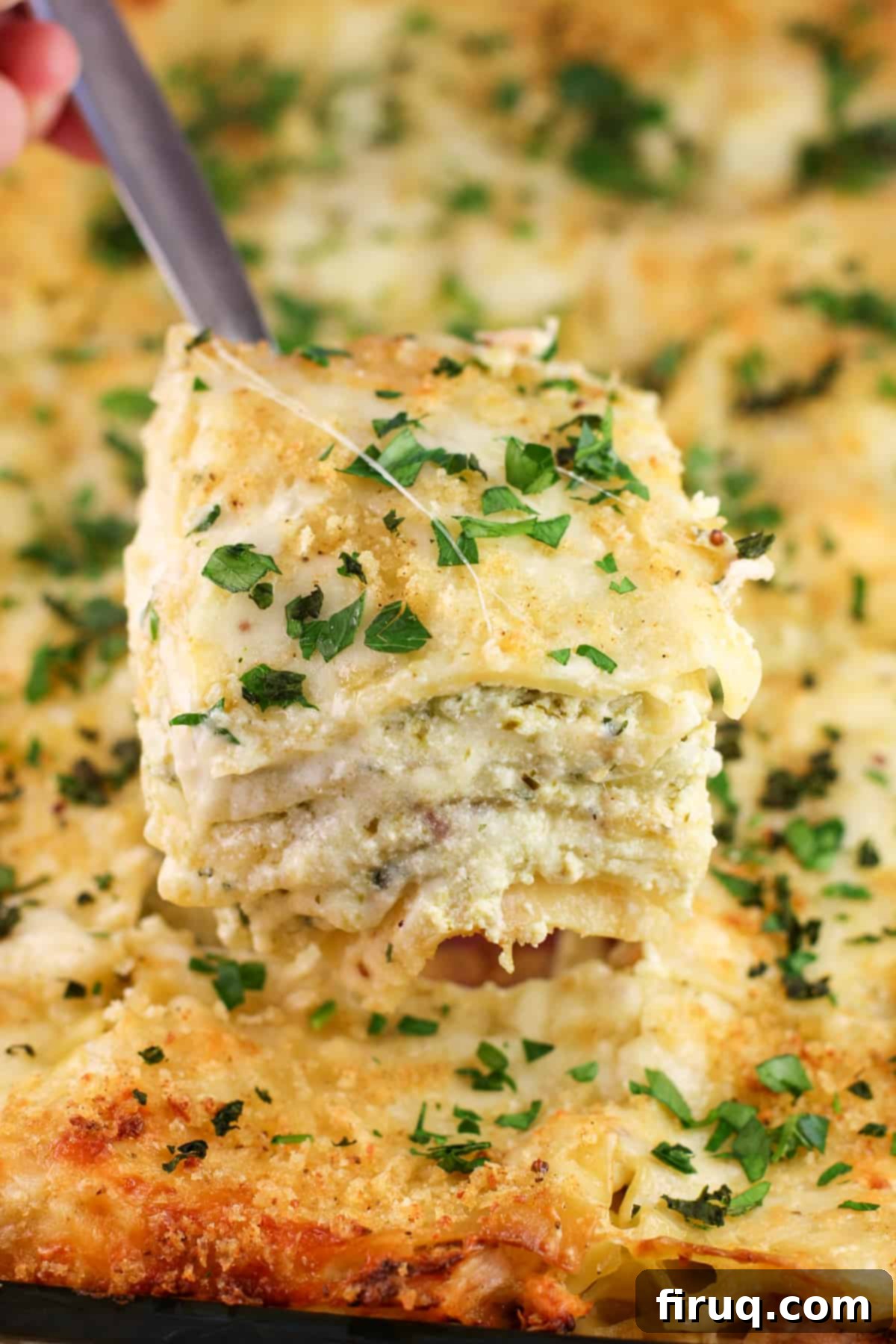 Rich Pesto Salmon Lasagna 12 spatula holding a large square of lasagna