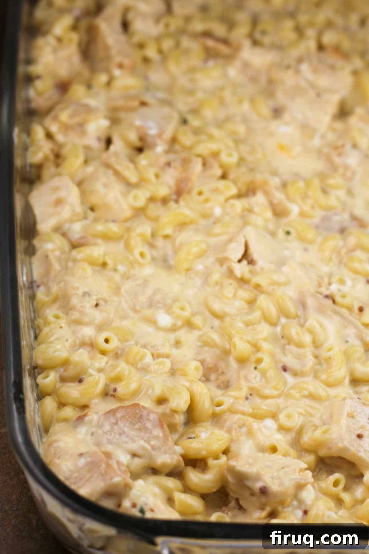 Ultimate Cheesy Chicken Macaroni Casserole 3 Close-up of ingredients assembled in a baking dish, before being topped with cheese, showing diced chicken and macaroni mixed in a creamy sauce.