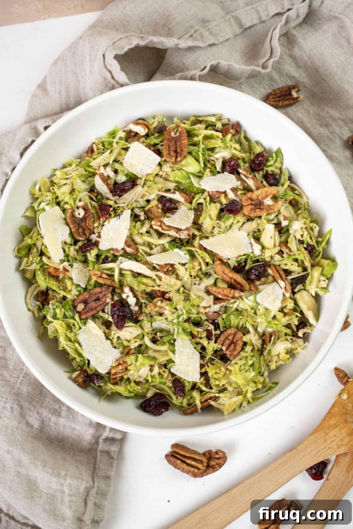 Brussels Sprout Salad with Crispy Pancetta 10 Brussels sprouts salad in a bowl topped with dried cranberries and pecans.