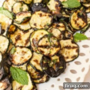 Zesty Marinated Zucchini 10 Zucchini alla scapece on a tray garnished with mint.