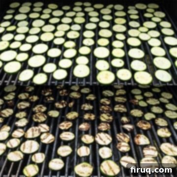 Zesty Marinated Zucchini 7 Zucchini slices being perfectly grilled on hot grill grates, showing char marks.