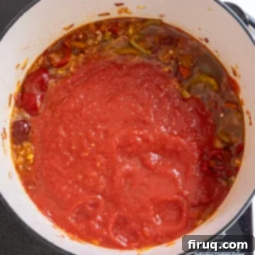 Spicy Chicken Rigatoni 10 Crushed tomatoes added to the simmering spicy base, ready to be incorporated.