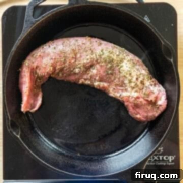 Rustic Italian Cast Iron Pork Tenderloin 5 Searing pork tenderloin on a hot cast iron pan, creating a delicious crust.