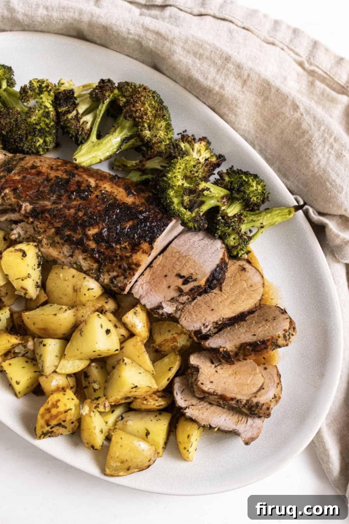 Rustic Italian Cast Iron Pork Tenderloin 10 Beautifully sliced Italian Cast Iron Pork Tenderloin served alongside roasted potatoes and vibrant green broccoli, garnished with fresh herbs.