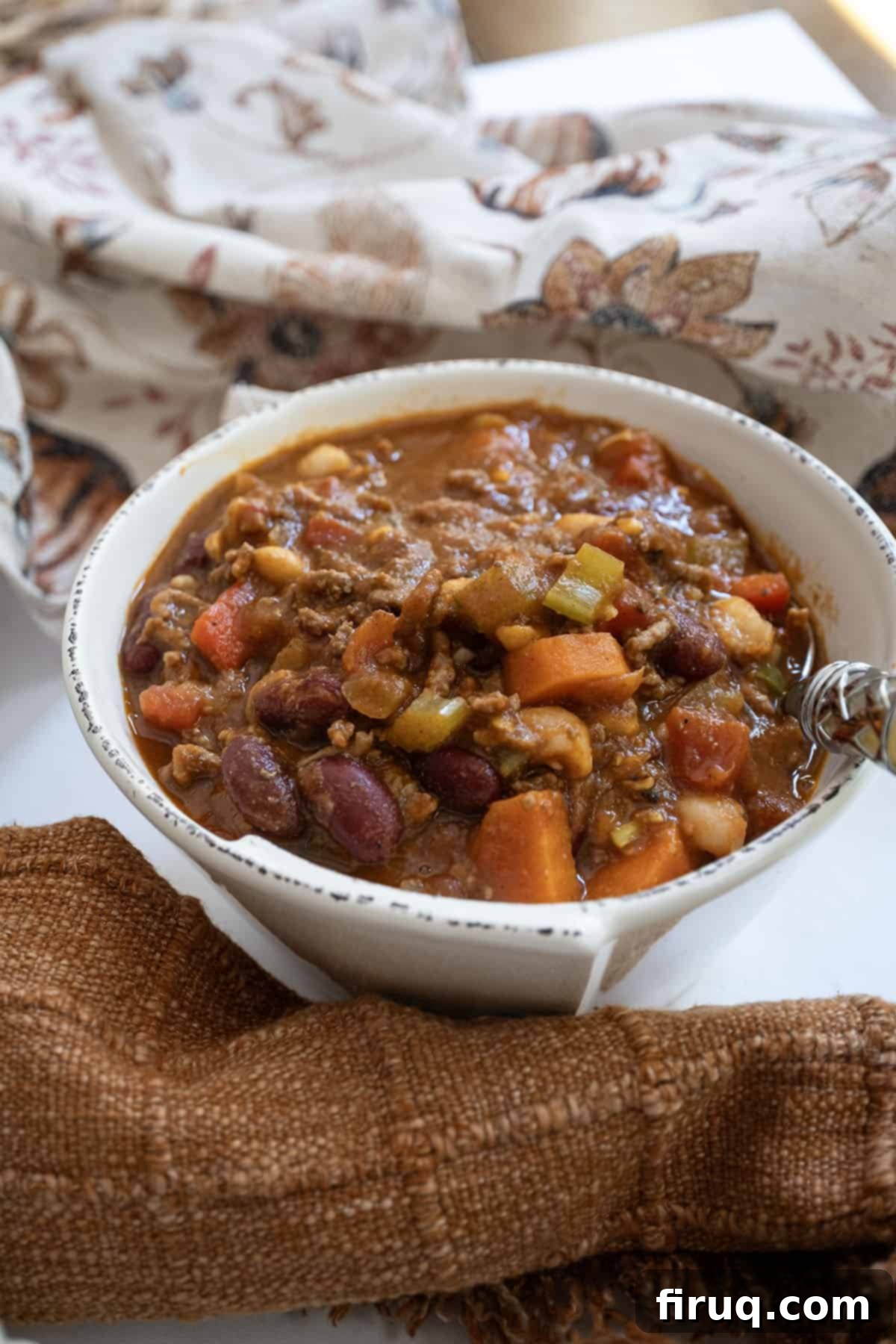 Golden Harvest Chili 2 Bowl of pumpkin chili with a spoon. A hearty and flavorful White Bean Pumpkin Chili, perfect for fall and football season.