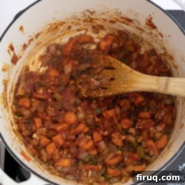 Golden Harvest Chili 7 Tomato paste caramelizing with vegetables in dutch oven, creating a rich flavor base.