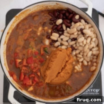 Golden Harvest Chili 10 Beans, peppers, and pumpkin puree added to the chili in the dutch oven, completing the ingredient list.