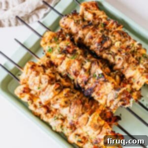 Irresistible Garlic Parmesan Chicken Skewers 12 Garlic parm chicken skewers on a baking pan.