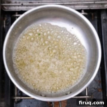 Irresistible Garlic Parmesan Chicken Skewers 6 Simmering butter and garlic with lemon in a pot.