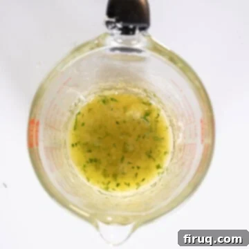 Irresistible Garlic Parmesan Chicken Skewers 9 Lemon garlic butter sauce in a measuring cup.