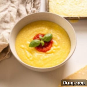 Velvety Smooth Polenta 9 Creamy polenta in a bowl topped with marinara and basil.