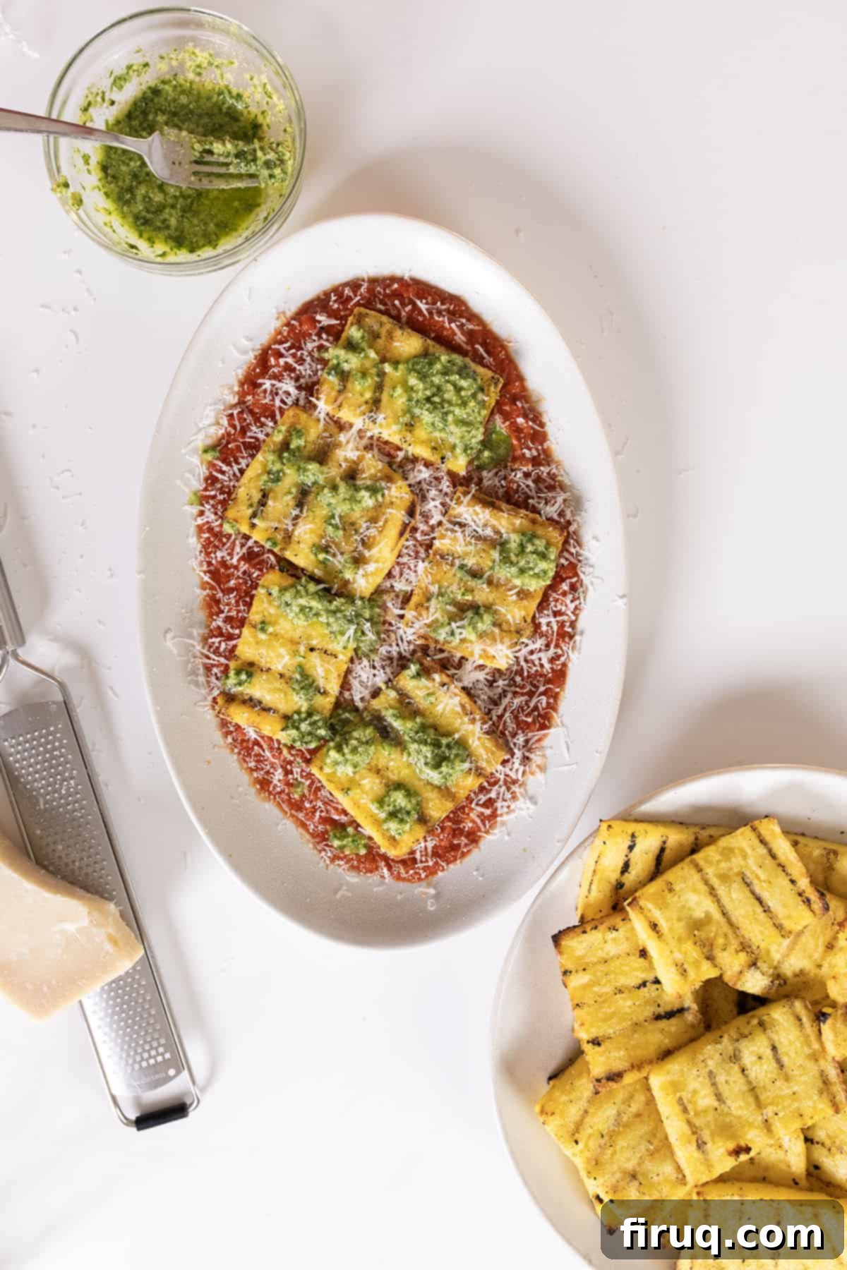 Golden Grilled Polenta with Marinara and Pesto 11 Final dish of grilled polenta on marinara topped with pesto and parmigiano, ready to be enjoyed.