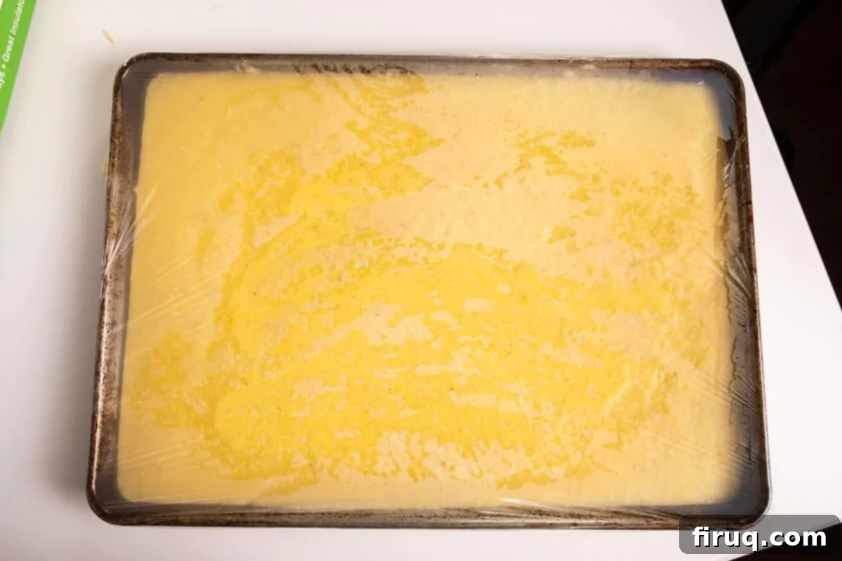 Golden Grilled Polenta with Marinara and Pesto 5 Chilled creamy polenta spread evenly in a baking sheet, ready to be cut into shapes.
