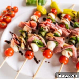Mini Caprese Bites 7 Caprese skewers on a plate drizzled with balsamic glaze, looking fresh and appetizing.
