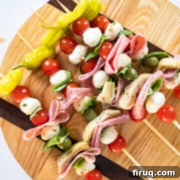 Mini Caprese Bites 4 A close-up of a skewer being assembled with vegetables, cheese, and salami.