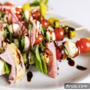 Mini Caprese Bites 5 Finished Caprese skewers on a serving plate, drizzled with balsamic glaze.