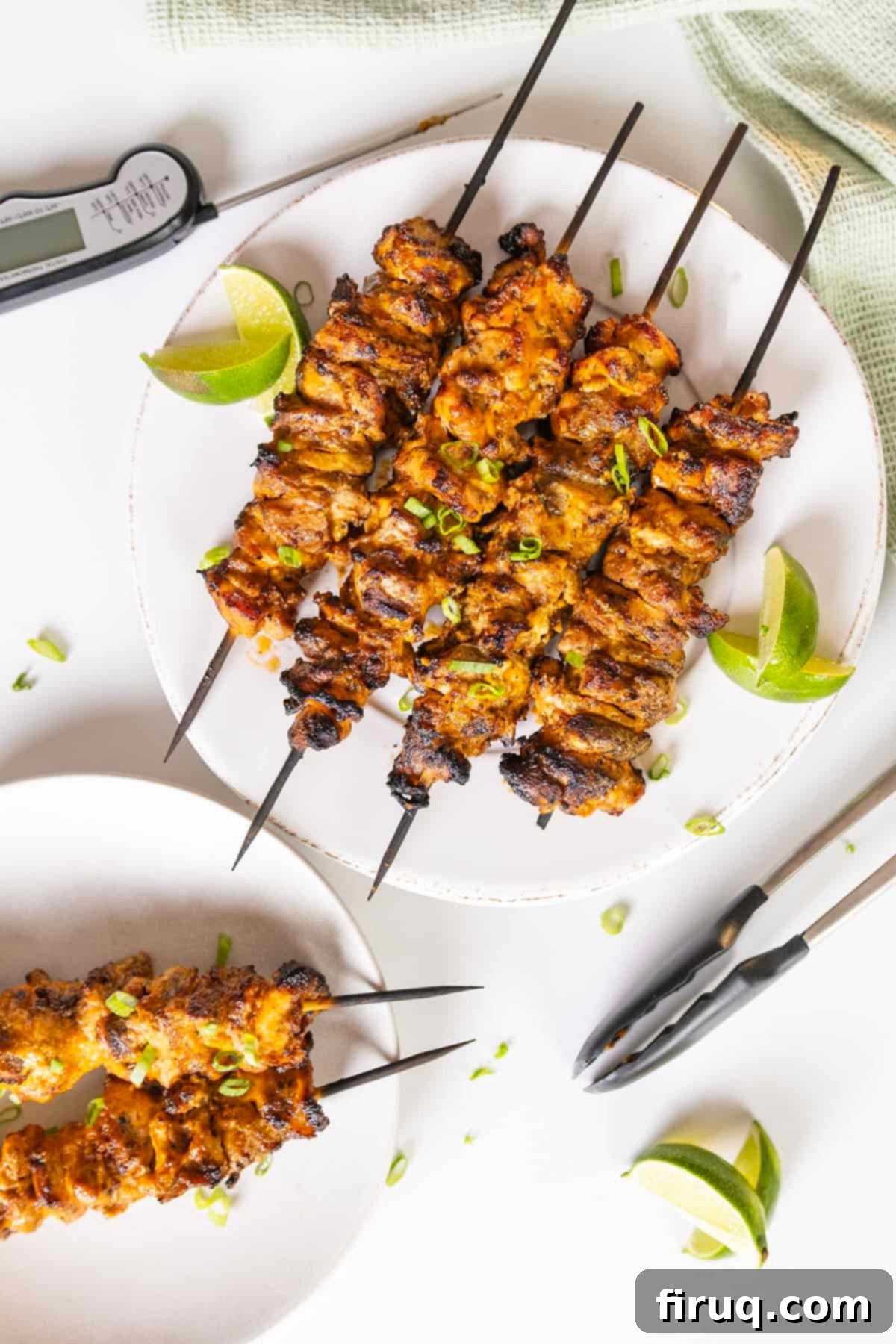 Zesty Bang Bang Chicken Skewers 2 Crispy, tender Bang Bang Chicken Skewers served with lime wedges, ready to eat.