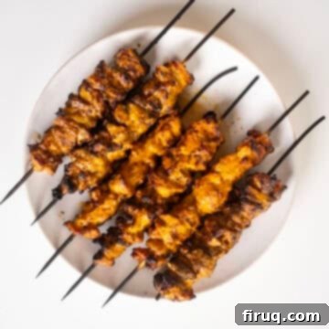 Zesty Bang Bang Chicken Skewers 11 Plated Bang Bang Chicken skewers garnished with fresh lime wedges and cilantro.