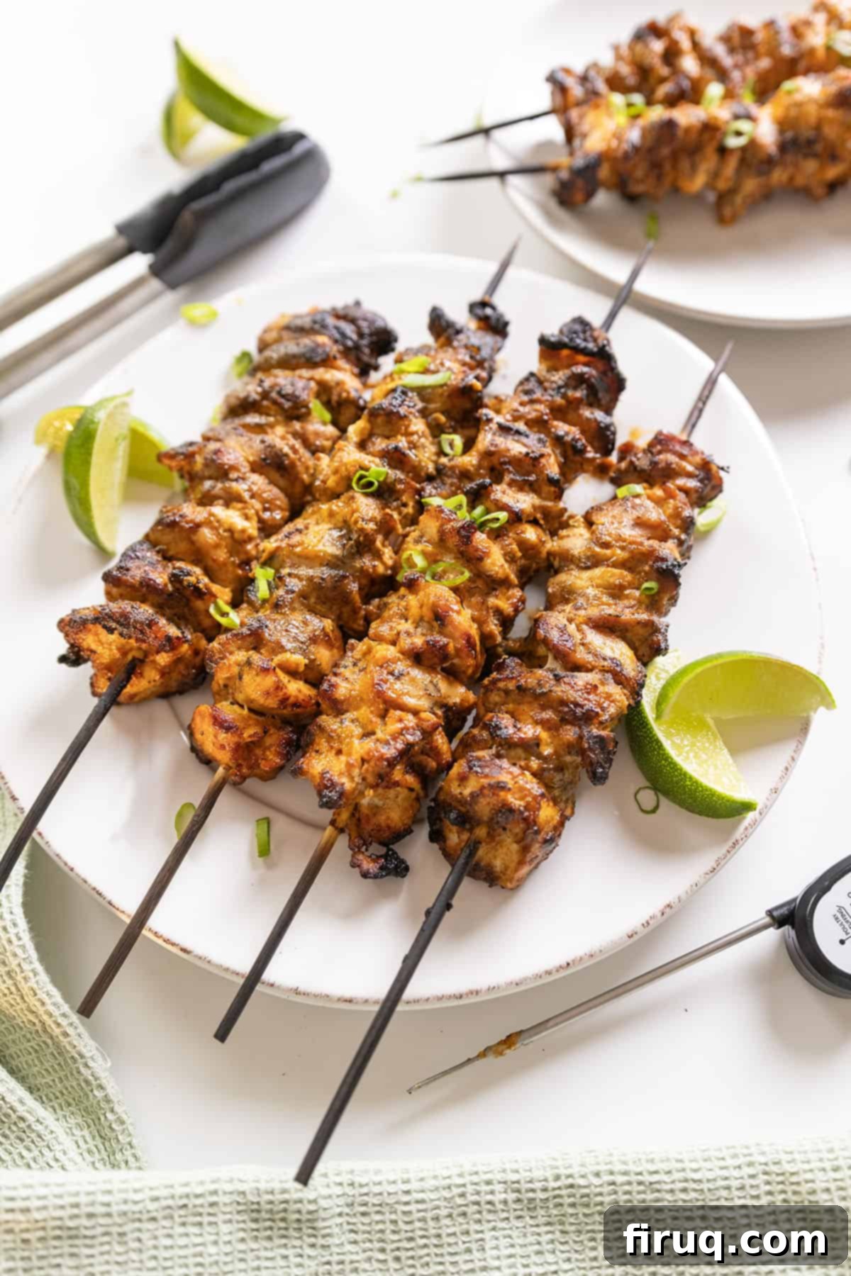 Zesty Bang Bang Chicken Skewers 12 Close-up of perfectly grilled Bang Bang Chicken skewers with fresh lime slices on a rustic plate.