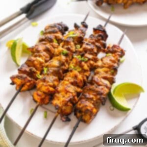 Zesty Bang Bang Chicken Skewers 13 Bang Bang Chicken skewers with limes on the side.