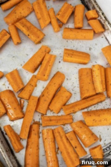Velvety Roasted Carrot Ginger Soup 3 seasoned carrots on baking tray