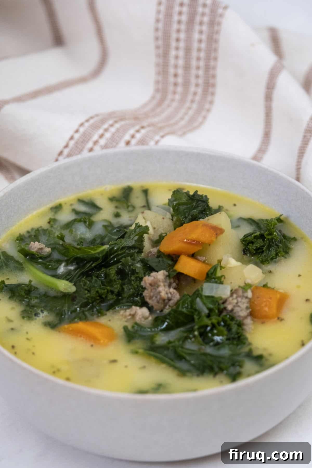 Creamy Tuscan Sausage and Potato Soup 11 A serving of creamy Zuppa Toscana in a bowl, garnished with fresh parsley and a sprinkle of Parmesan cheese.