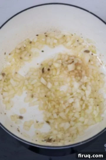 Creamy Tuscan Sausage and Potato Soup 5 Chopped onions sautéing in a Dutch oven.