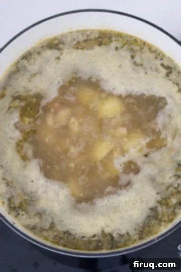 Creamy Tuscan Sausage and Potato Soup 8 Zuppa Toscana soup simmering gently on the stovetop.