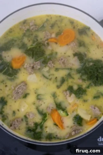 Creamy Tuscan Sausage and Potato Soup 10 Heavy cream being gently stirred into the finished Zuppa Toscana.