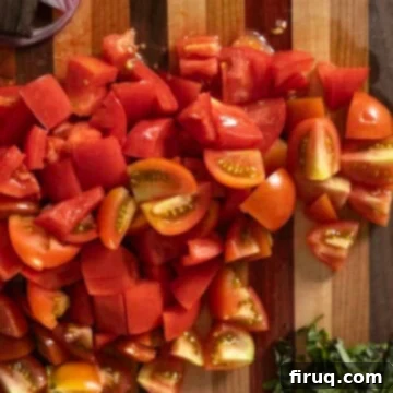 Rustic Tuscan Panzanella 5 Vibrantly red, chopped tomatoes arranged on a wooden cutting board, ready for the salad.
