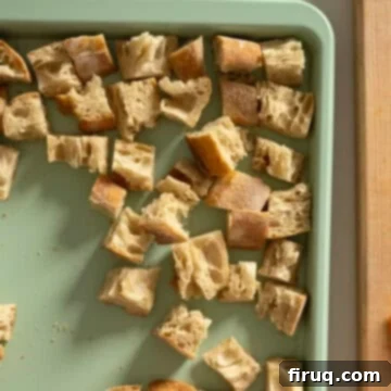 Rustic Tuscan Panzanella 6 Dried bread cubes evenly spread on a baking sheet, cooling after being toasted.