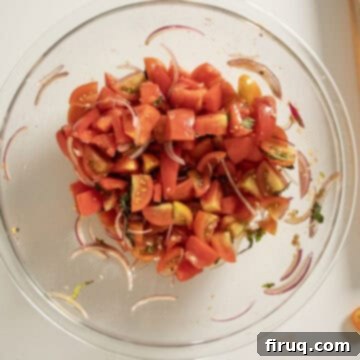 Rustic Tuscan Panzanella 7 A large mixing bowl containing chopped tomatoes, red onion, and basil, ready to be dressed.