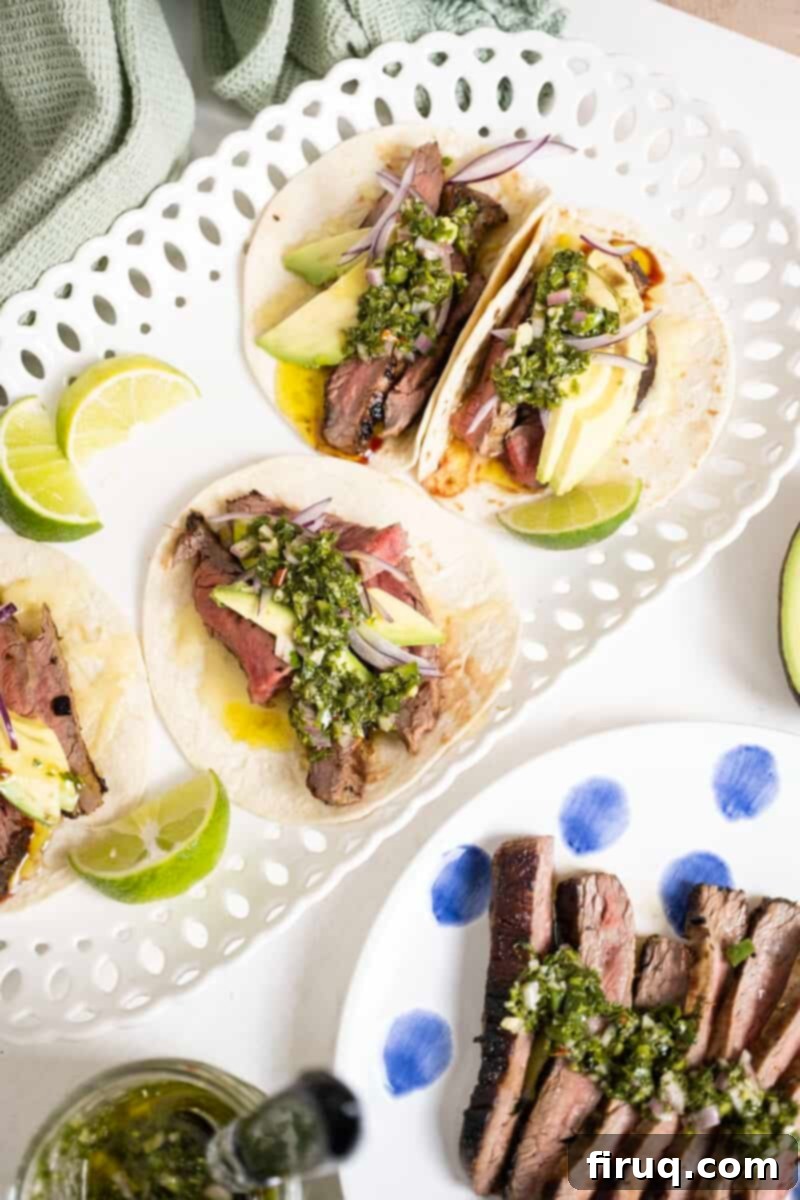 Vibrant Chimichurri Steak Tacos 2 Chimichurri steak tacos on a plate with limes.