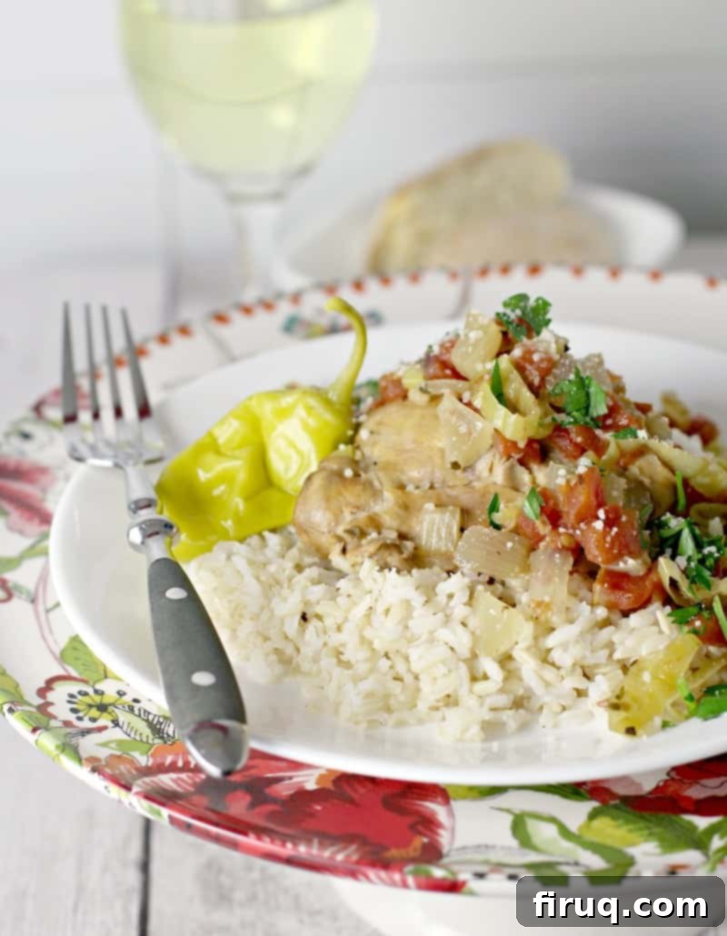 One-Pot Zesty Italian Pepperoncini Chicken 2 Side view showing cooked Italian pulled chicken served over fluffy rice, with crusty bread and a glass of white wine in the background, ready for a delicious meal.