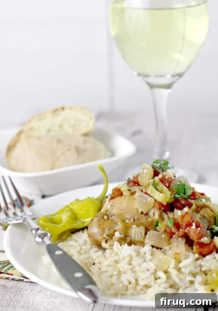 One-Pot Zesty Italian Pepperoncini Chicken 7 View showing cooked Slow Cooker Italian Pepperoncini Chicken served over rice, with crusty bread and a glass of white wine in the background, set for a delightful dinner.