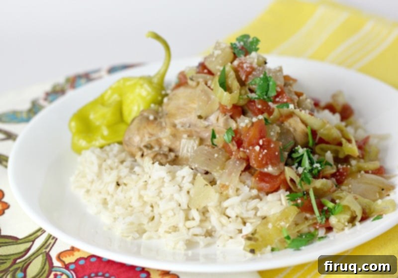 One-Pot Zesty Italian Pepperoncini Chicken 9 Side view showing cooked Italian pulled chicken slow cooker served over rice on a white dish on top of a a yellow napkin.