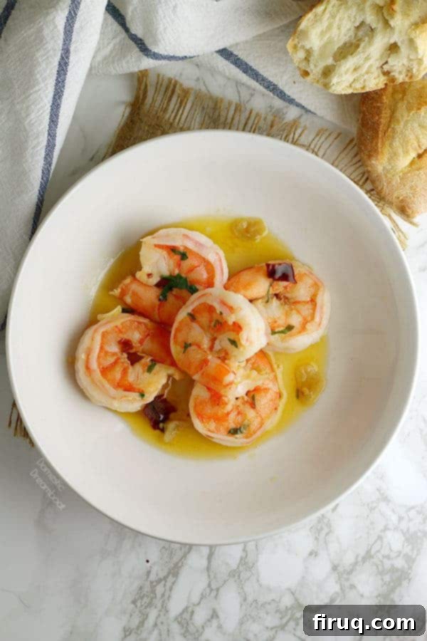Garlic Shrimp Cooking Mediterranean Garlic Shrimp cooking in a skillet with olive oil, bay leaf, and sliced garlic.