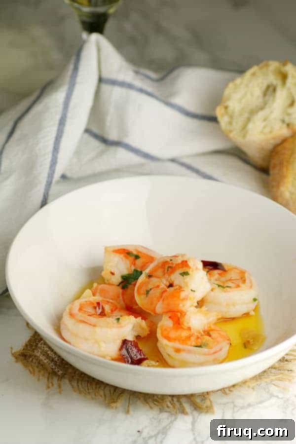 Served Garlic Shrimp A serving of Mediterranean Garlic Shrimp with a side of crusty bread, ready to be enjoyed.