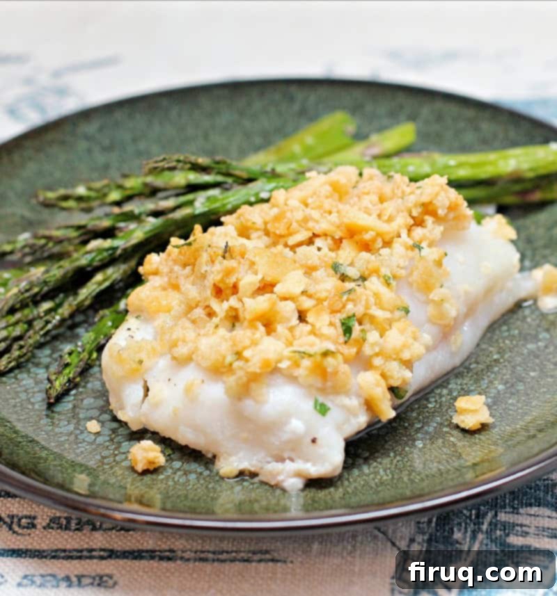 Classic Boston Baked Cod 5 cooked fish topped with cracker stuffing on a green plate with asparagus