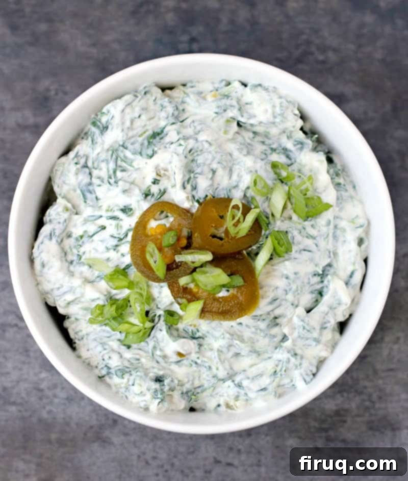 Zesty Slim Spinach Dip 5 top down view of this recipe in a bowl topped with 3 slices jalapeno