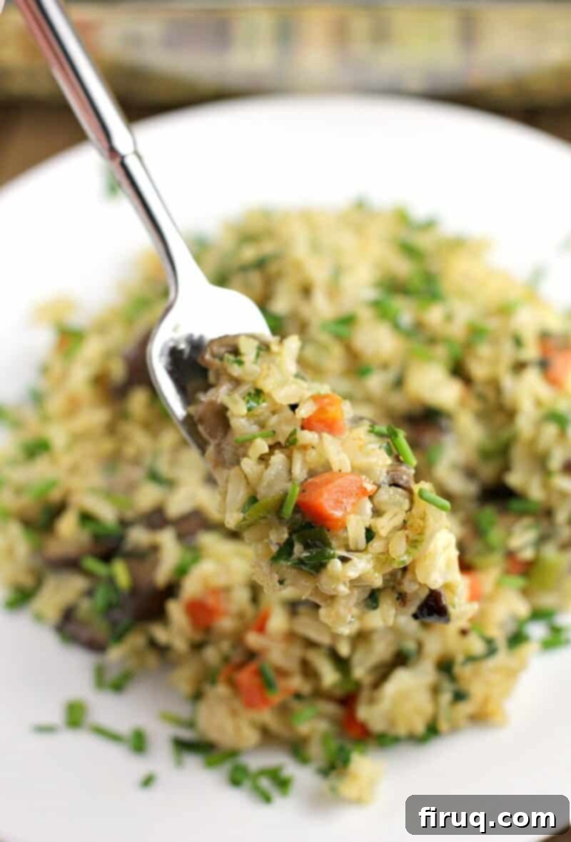 Comforting Veggie Rice Bake 3 fork holding up a bite-sized amount of rice casserole