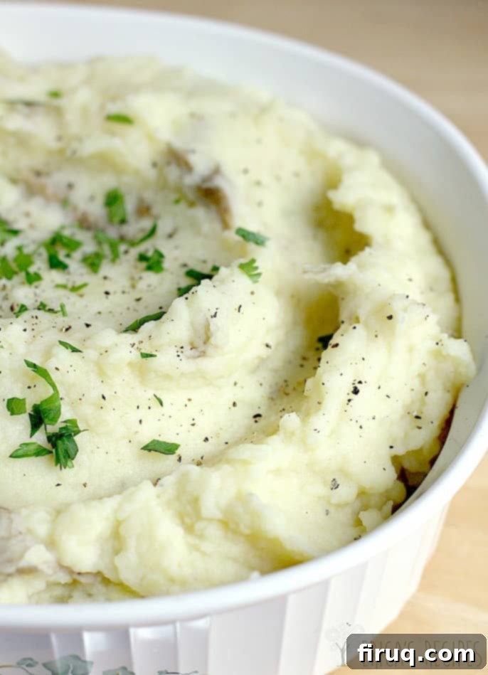 Velvety Cream Cheese Smashed Potatoes 4 A vibrant plate of Cream Cheese Smashed Potatoes, ready to be served, garnished with fresh herbs.