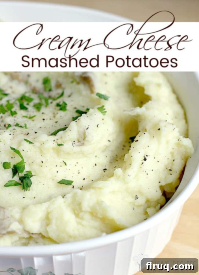Velvety Cream Cheese Smashed Potatoes 5 Overhead shot of Cream Cheese Smashed Potatoes in a rustic bowl, garnished with green onions and a sprinkle of black pepper, perfect for holiday gatherings or family meals.