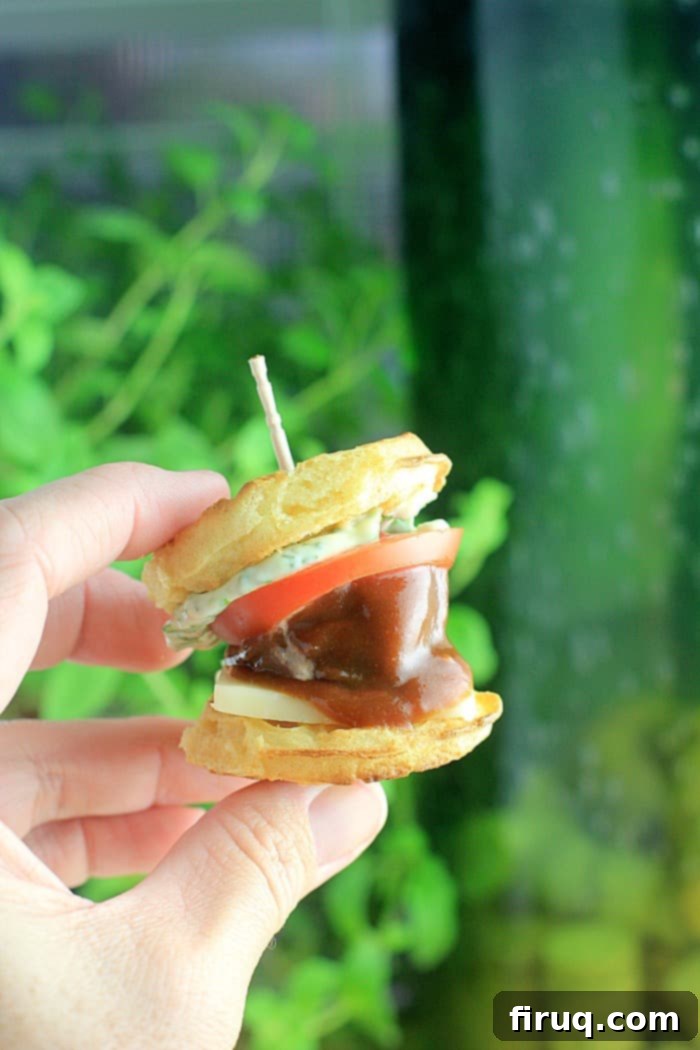Smoky BBQ Meatball Waffle Sliders 4 hand holding a meatball sandwiched between mini waffles